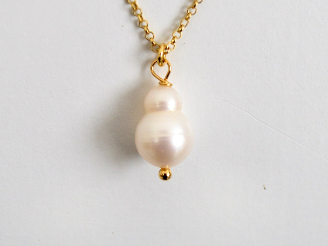 Nahaufnahme des weißen Barockperlenanhängers der vergoldeten Peanut Pearls Kette