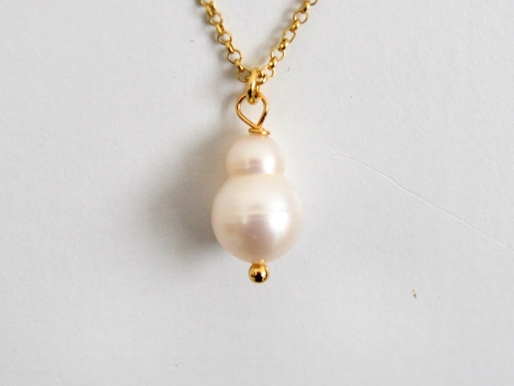 Nahaufnahme des weißen Barockperlenanhängers der vergoldeten Peanut Pearls Kette
